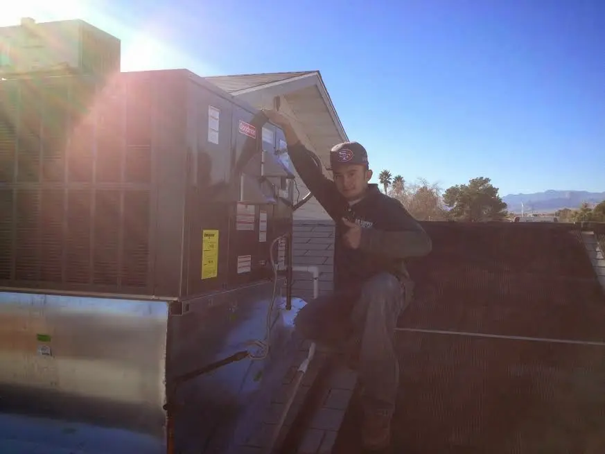 HVAC technician performing AC Tune-Up on a rooftop unit in Claremont